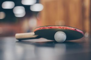 Table tennis paddle and ball on a table tennis table
